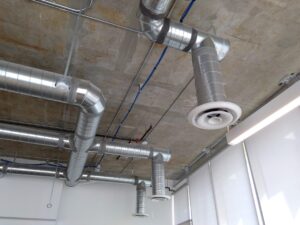 Art campus A: exposed concrete ceiling metal ducts echo sounds