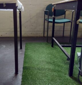 Faux grass floor covering to soften hardness and noise